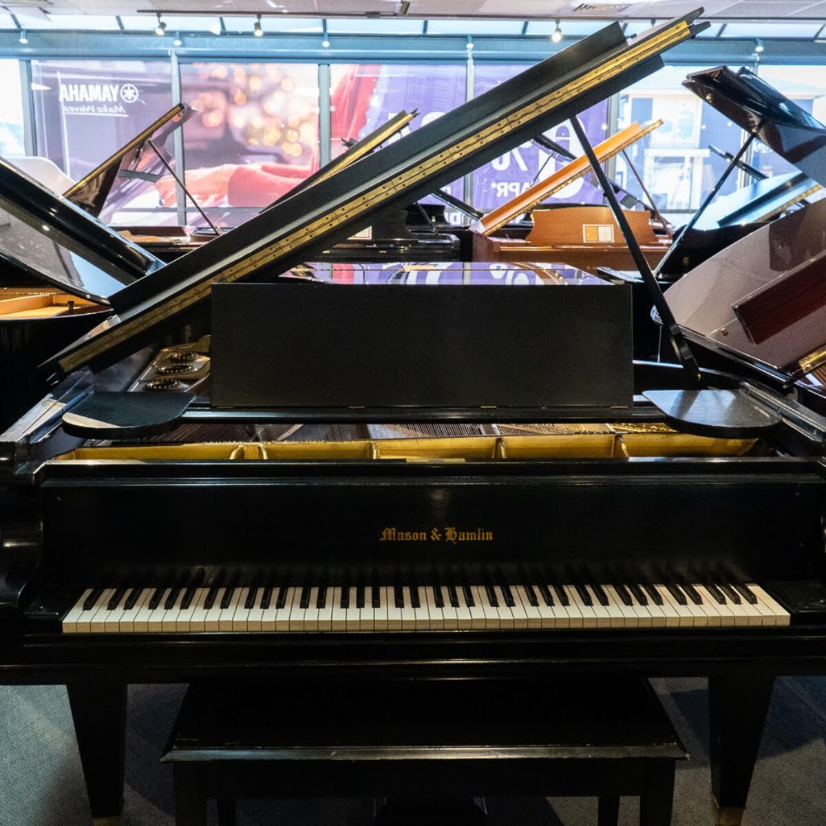 Mason & Hamlin grand piano displayed in showroom at Classic Pianos Denver. Premium craftsmanship and sound quality.