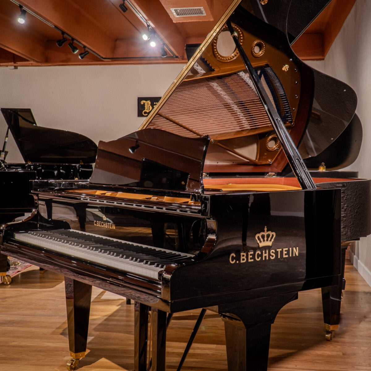 Alt text: Elegant C. Bechstein grand piano showcasing premium craftsmanship and rich, resonant sound quality in a stylish showroom.