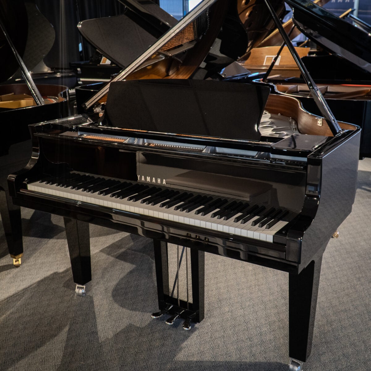 Yamaha grand piano with polished ebony finish, featuring responsive keys and high-quality sound for any performance setting.