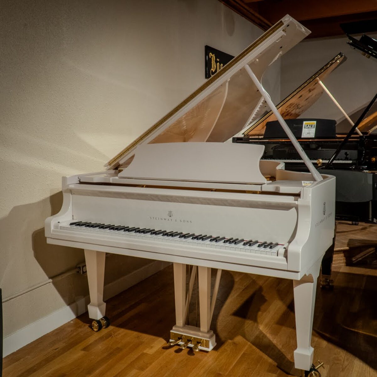 Alt text: Elegant Steinway & Sons grand piano in sleek white finish, showcasing premium craftsmanship and stunning aesthetic appeal.