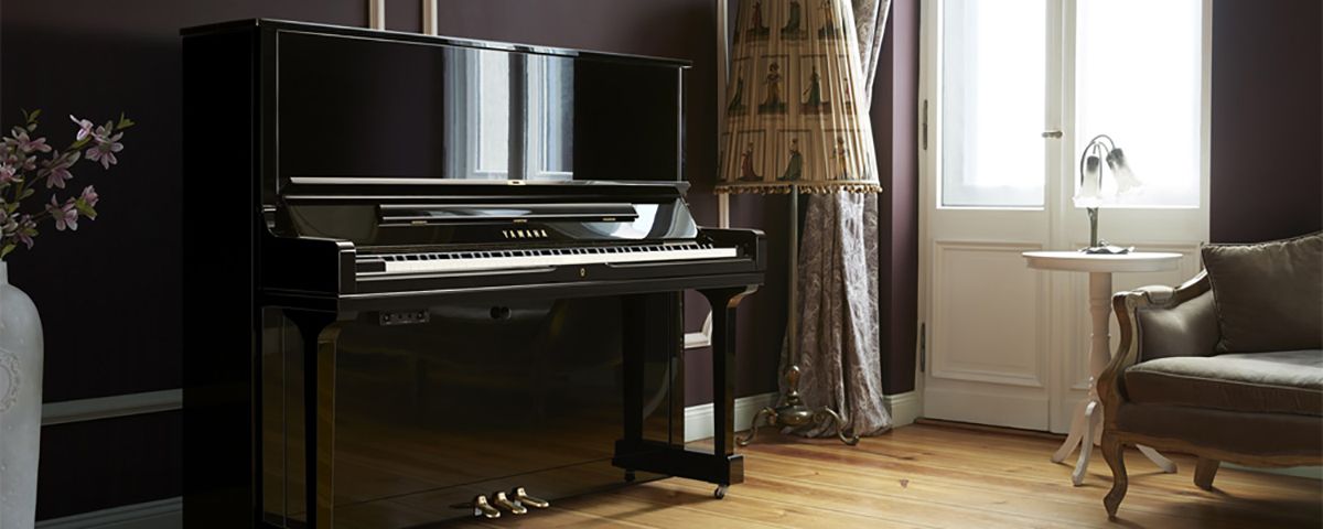 Man playing a Yamaha AvantGrand N3X Hybrid piano piano sitting in cozy classroom setting
