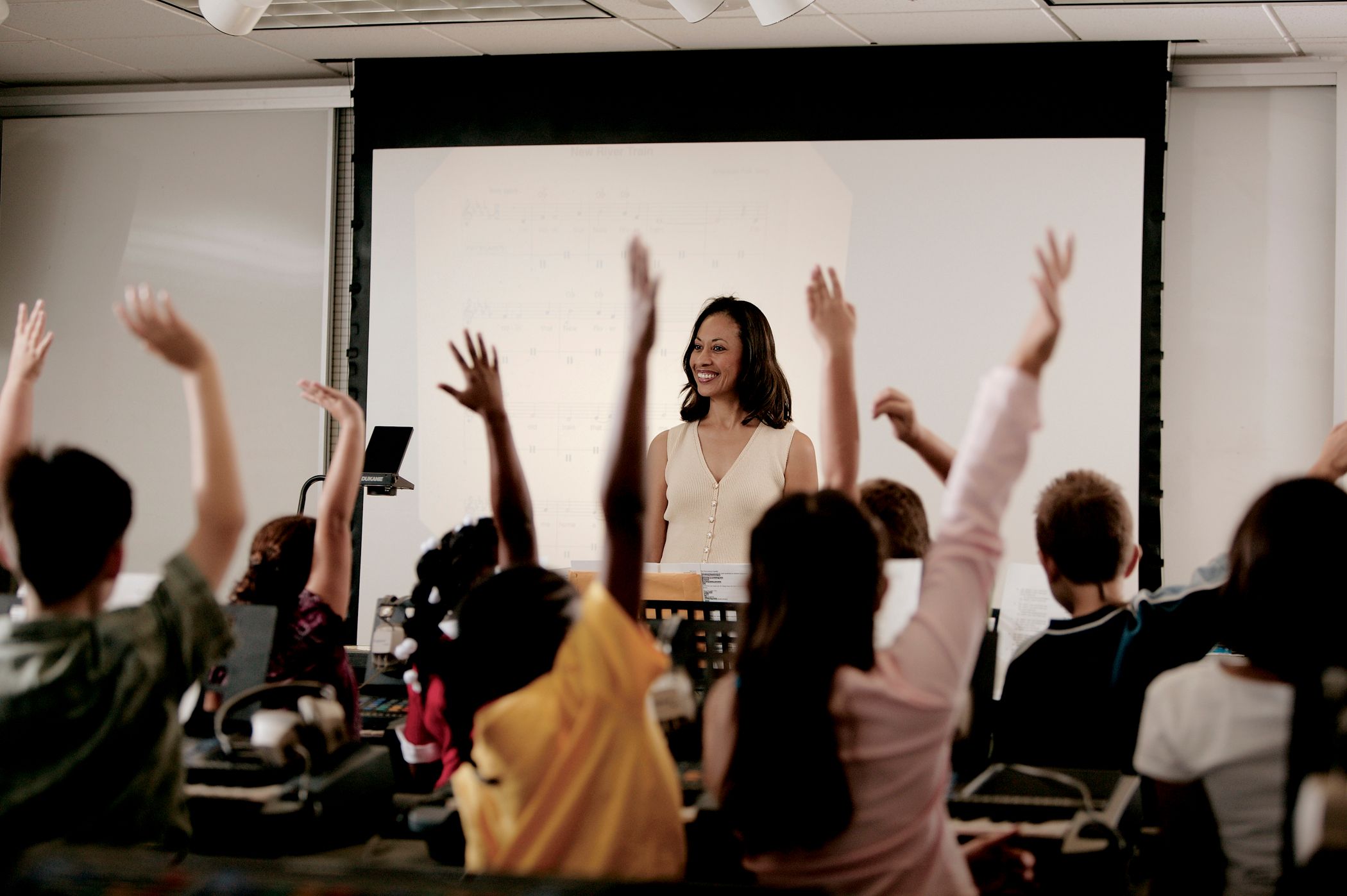 Top view of Yamaha’s CFX22 concert grand Woman at front of music classroom answering engaged students.