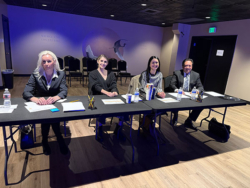 Four judges sit at a table with piano competition materials, assessing talent for Classic Pianos Denver event.